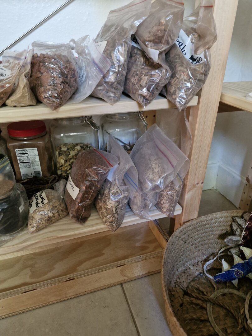 Shelves holding bags and jars of various herbs.