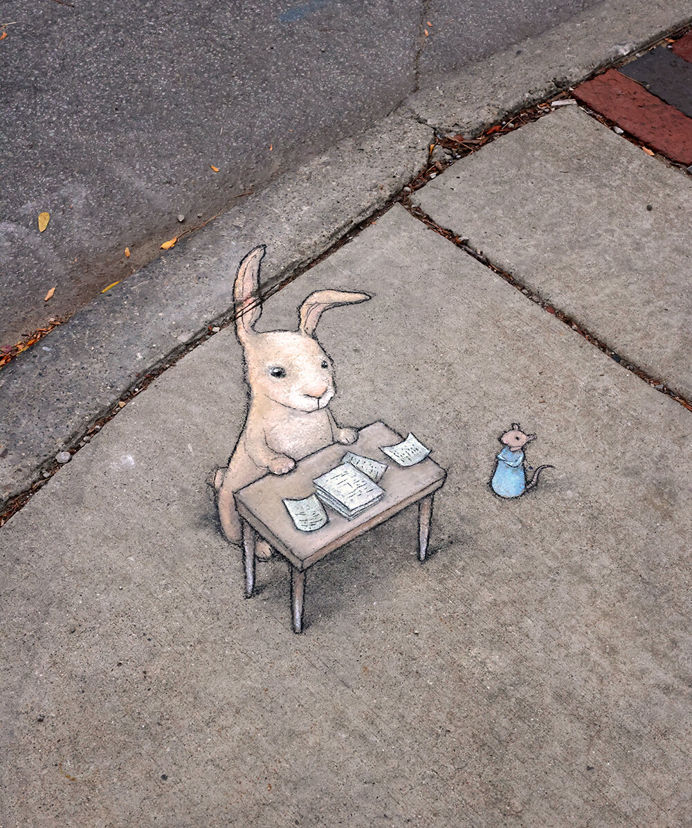 sidewalk chalk drawing of a mouse in a blue dress looking at a rabbit seated behind a desk of papers