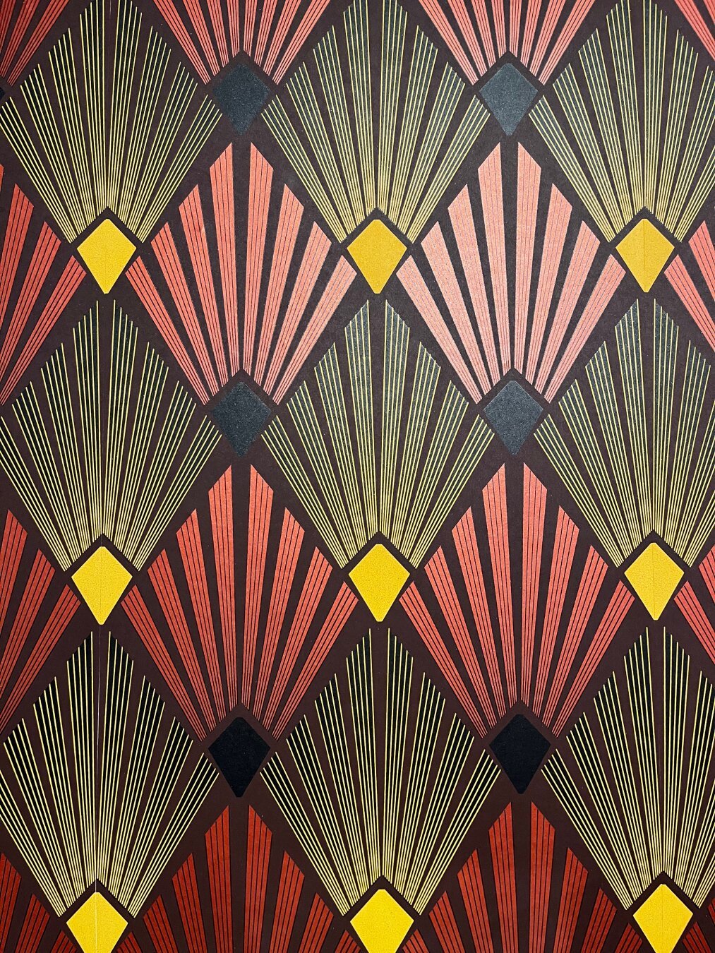 Art Deco wallpaper, papyrus leaves in geometric patterns on a black background, red, yellow and gold colors with shiny mica in places. From my Echoes of Art Deco exhibition at the Boghossian Foundation in Brussels