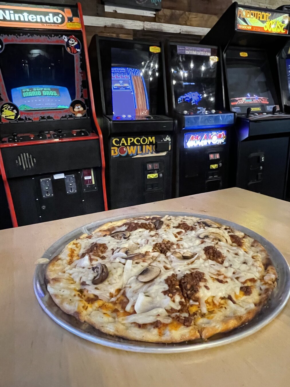 Pizza with arcade games in the background.