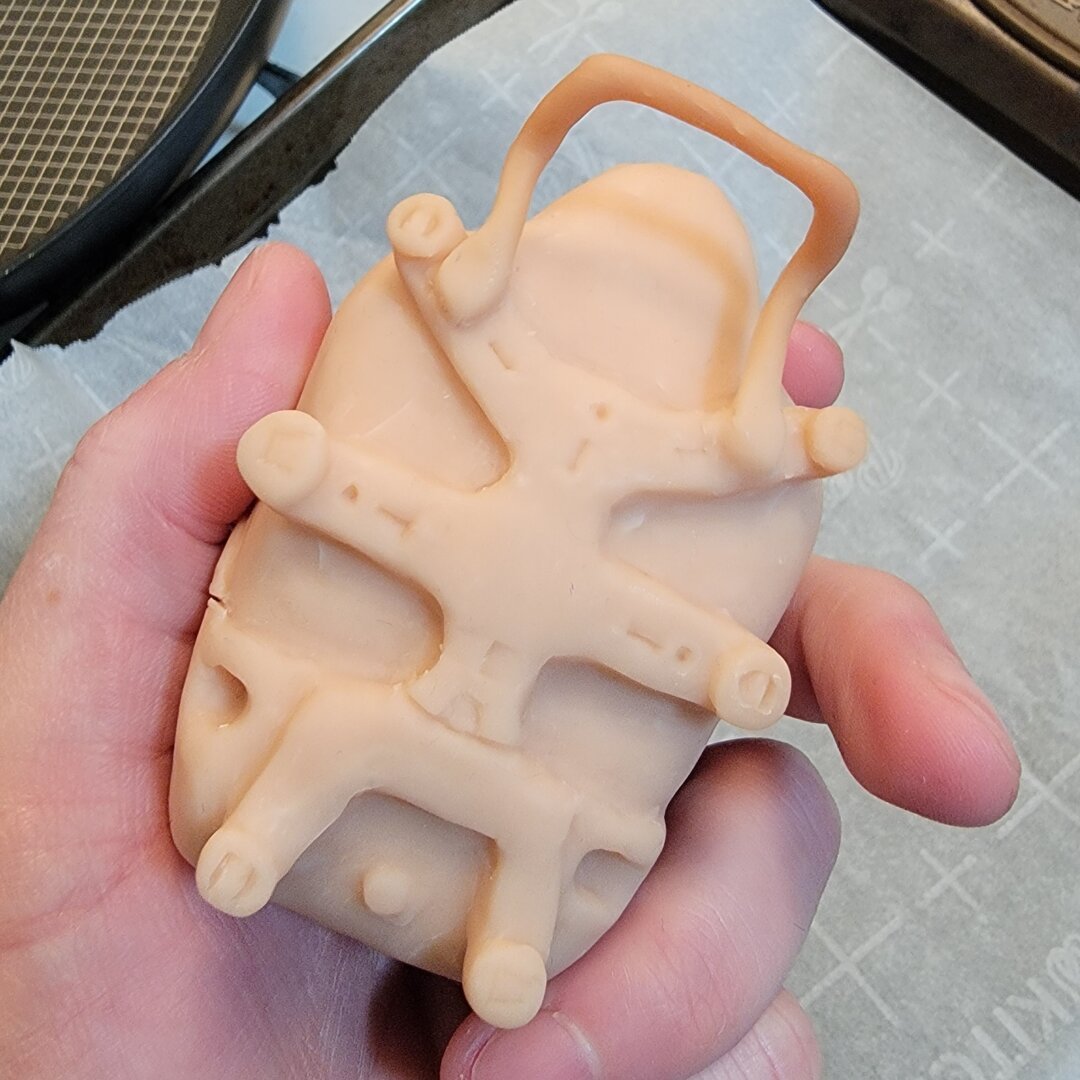 Photo of the back of the pod with the frame and handle that are used to mount it on the front of a porter's suit.