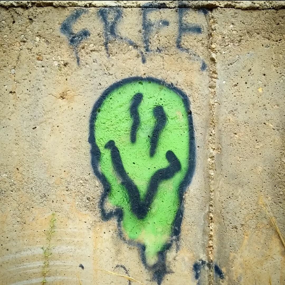 Drawing in a wall of a green melting smily and the word FREE

Pintada en la pared de un emoticono derretido verde y la palabra FREE