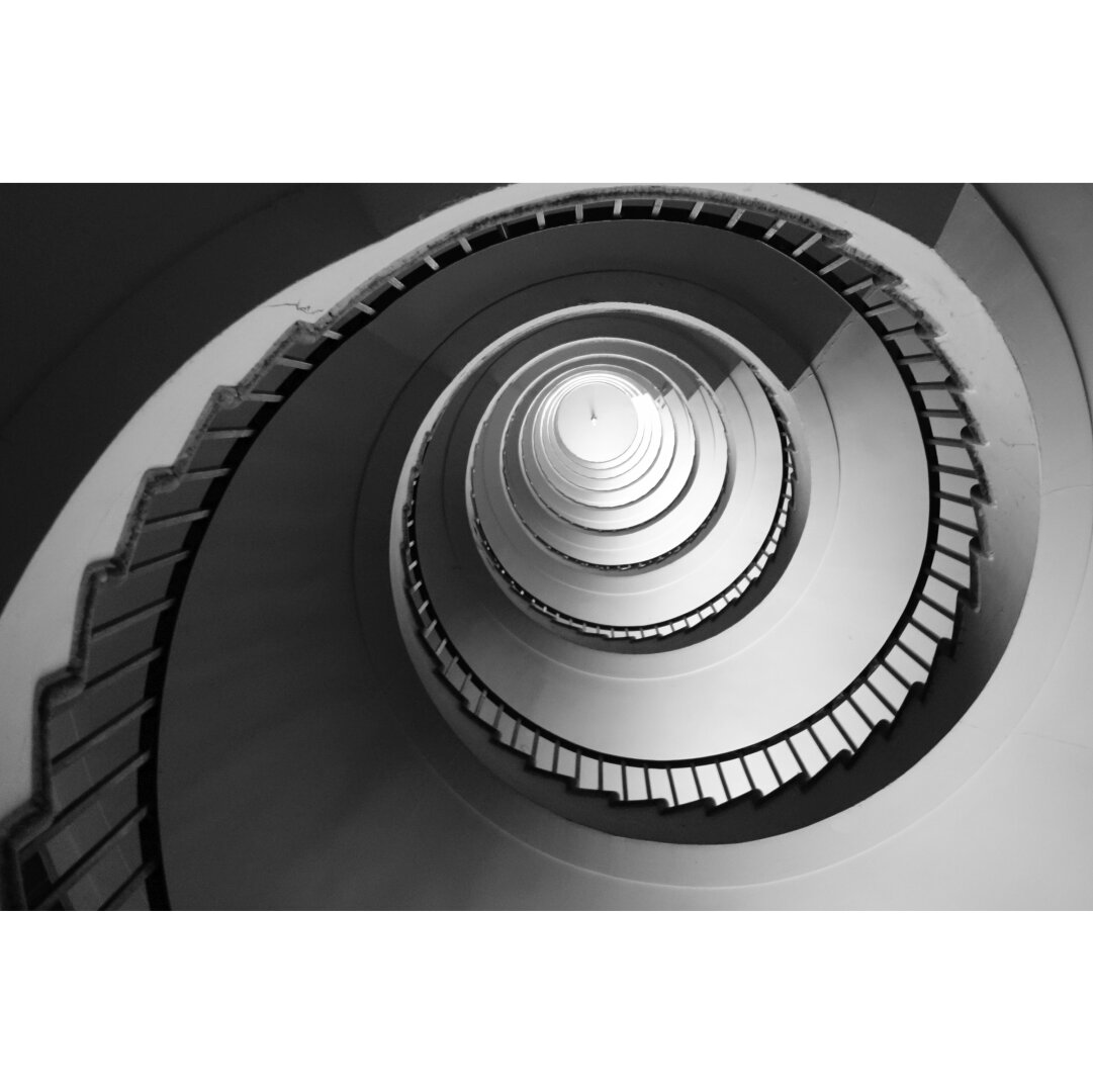 Black and white photo of a spiraling stairway. Black and white photo of a spiraling stairway.