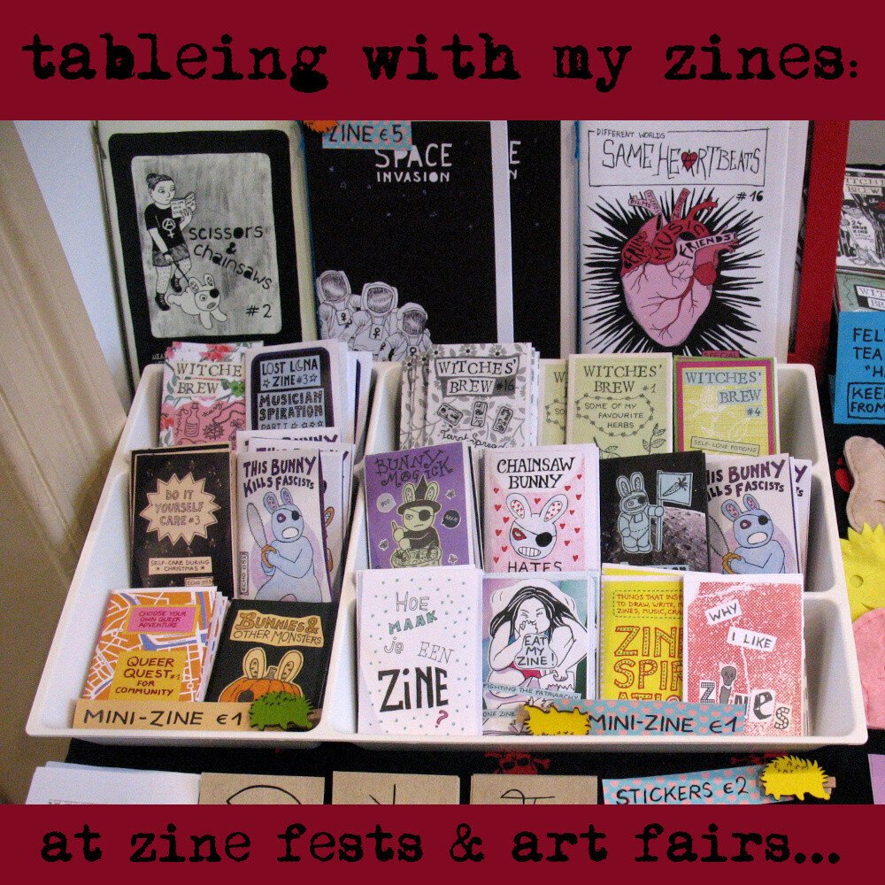 Table with mini-zines in cutlery box and bigger zines behind. Titles include 