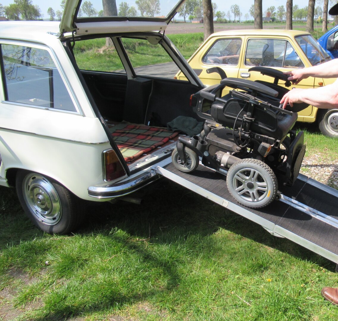 Peugeot 204 Break met oprijplaten en een rolstoel erop.