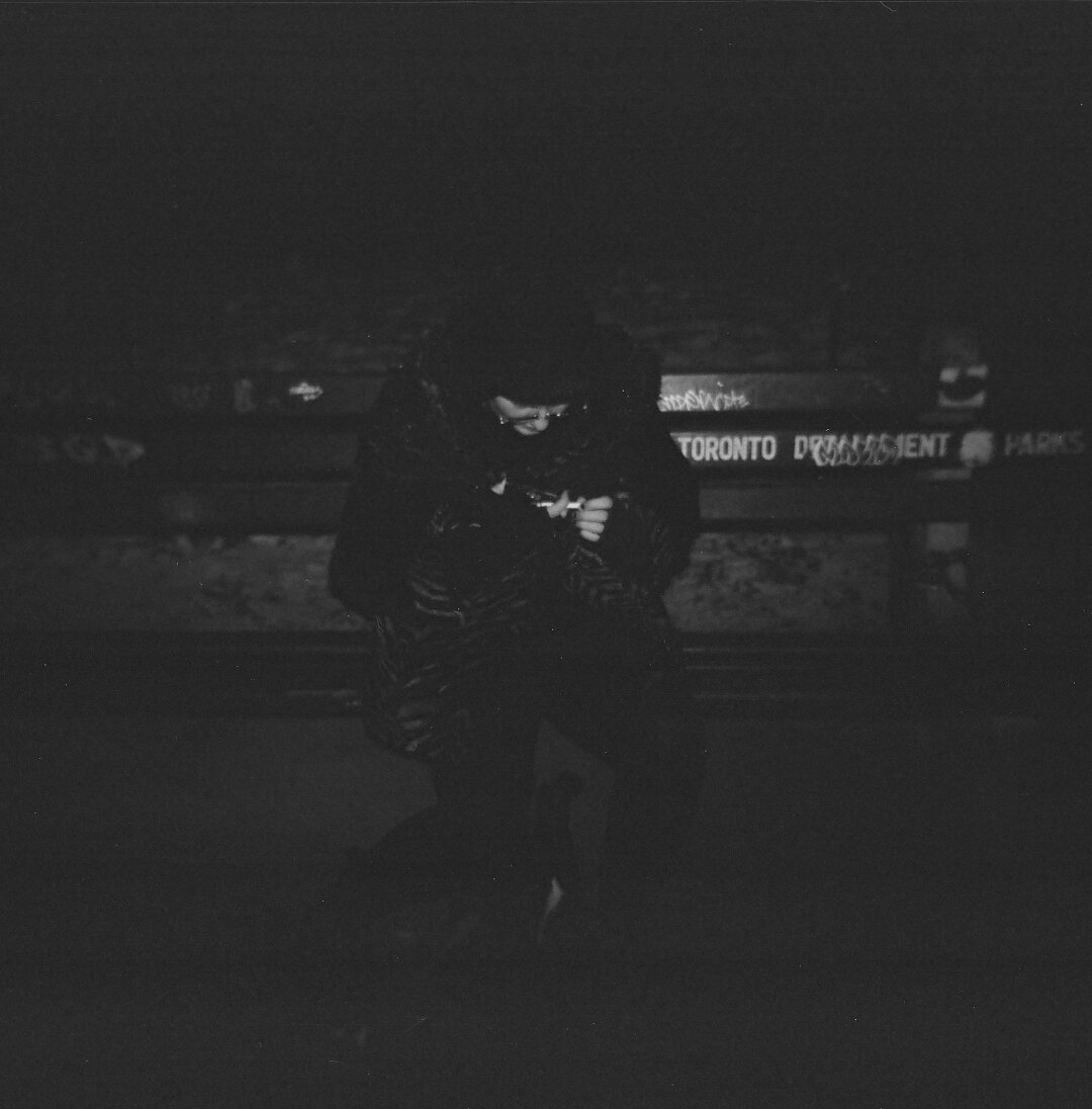 my partner sitting on a bench in the snow at night. holga 120cfn kentmere 400