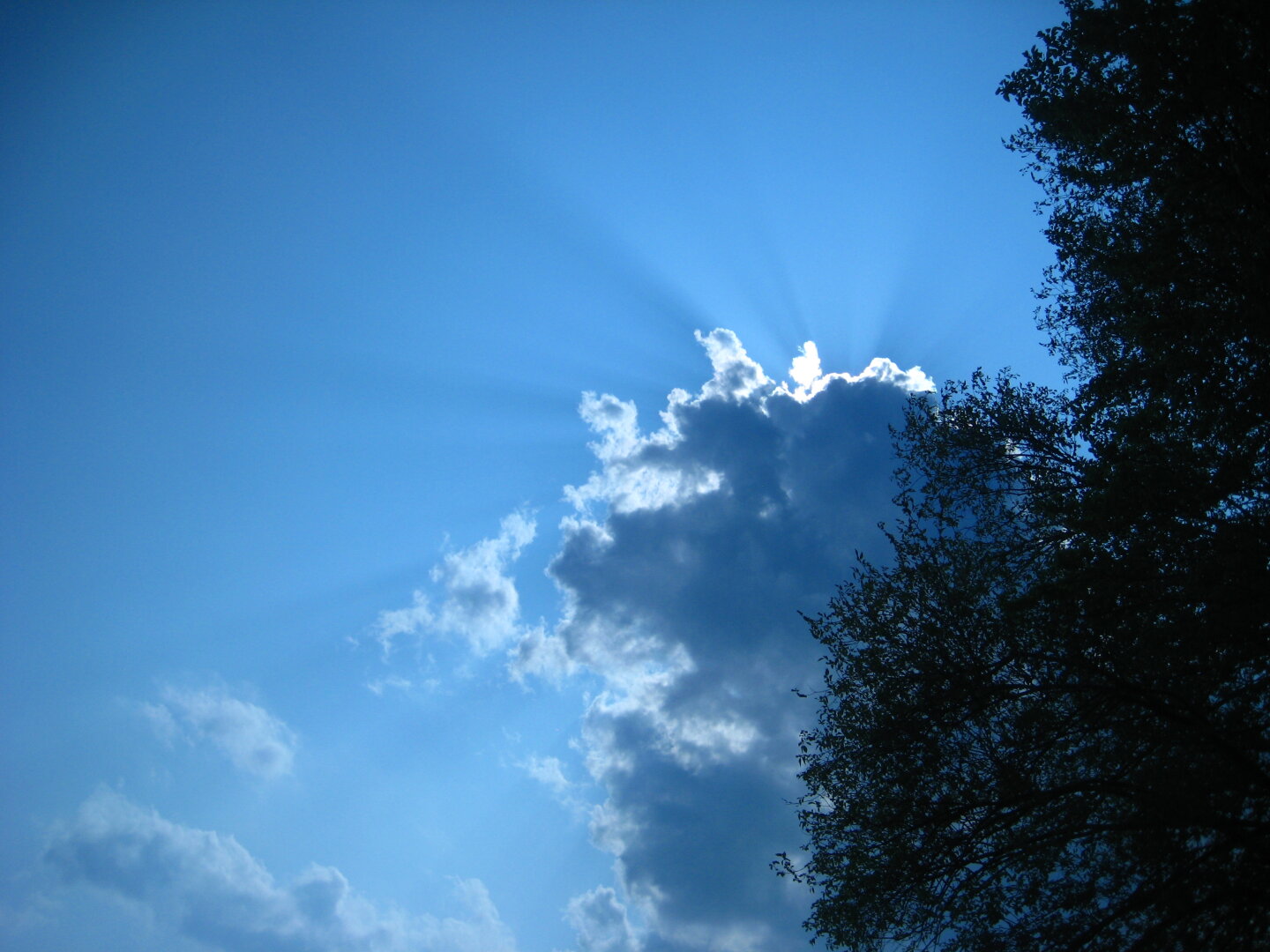 the sun just behind the clouds with a blue sky to the left