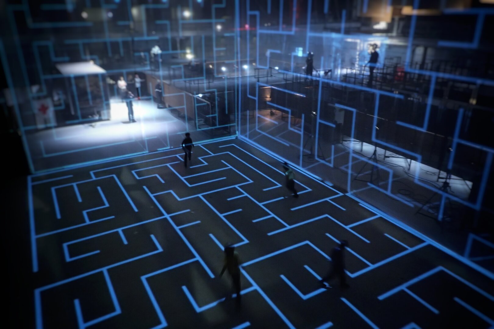 A giant projection mapped maze with kids playing around inside.