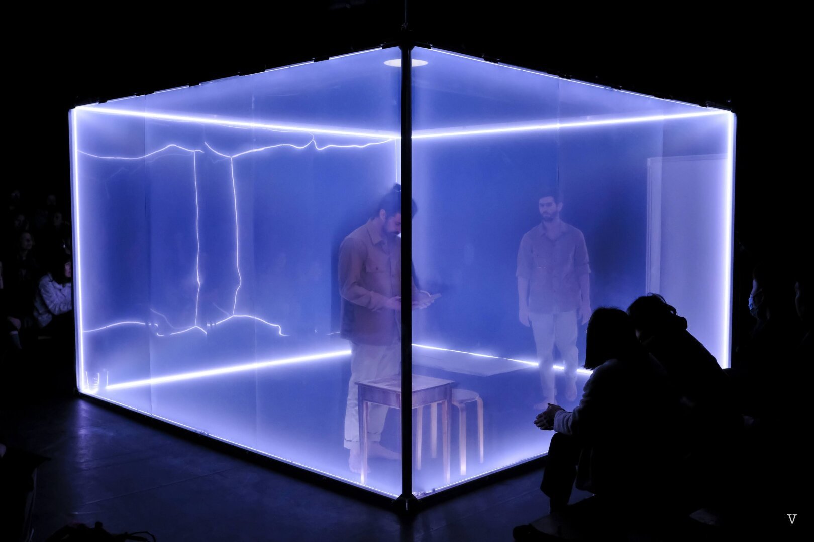 Two inmates in a transparent white cubic cell, or are they?