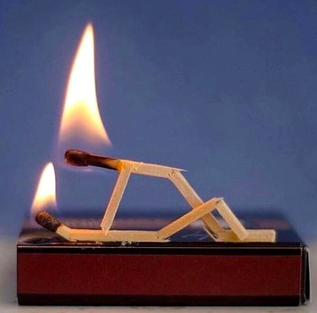 Photography. Two burning matches on a matchbox. They are laid and bent so that it looks like they are having sex.