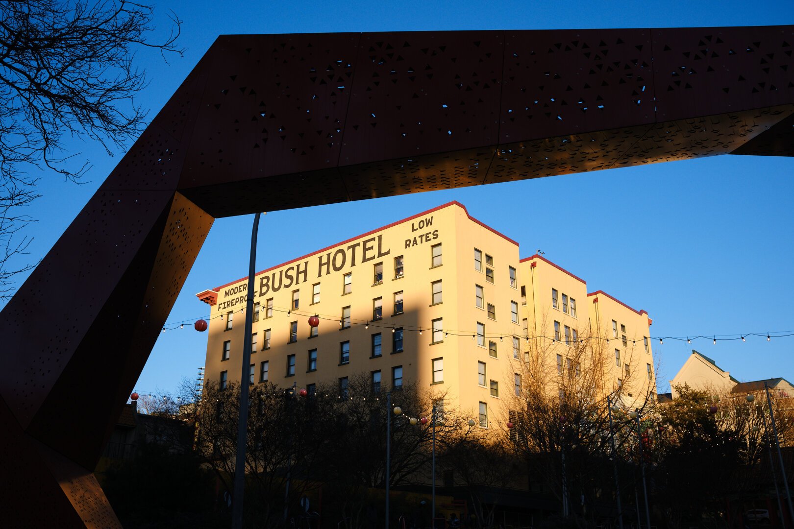 Bush Hotel, which is a apartment building in the International District in Seattle, WA, with a silhouetted sculpture arching over it.