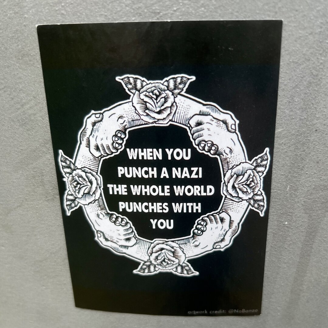 Hands in a circle with the text “when you punch a nazi the whole world punches with you”