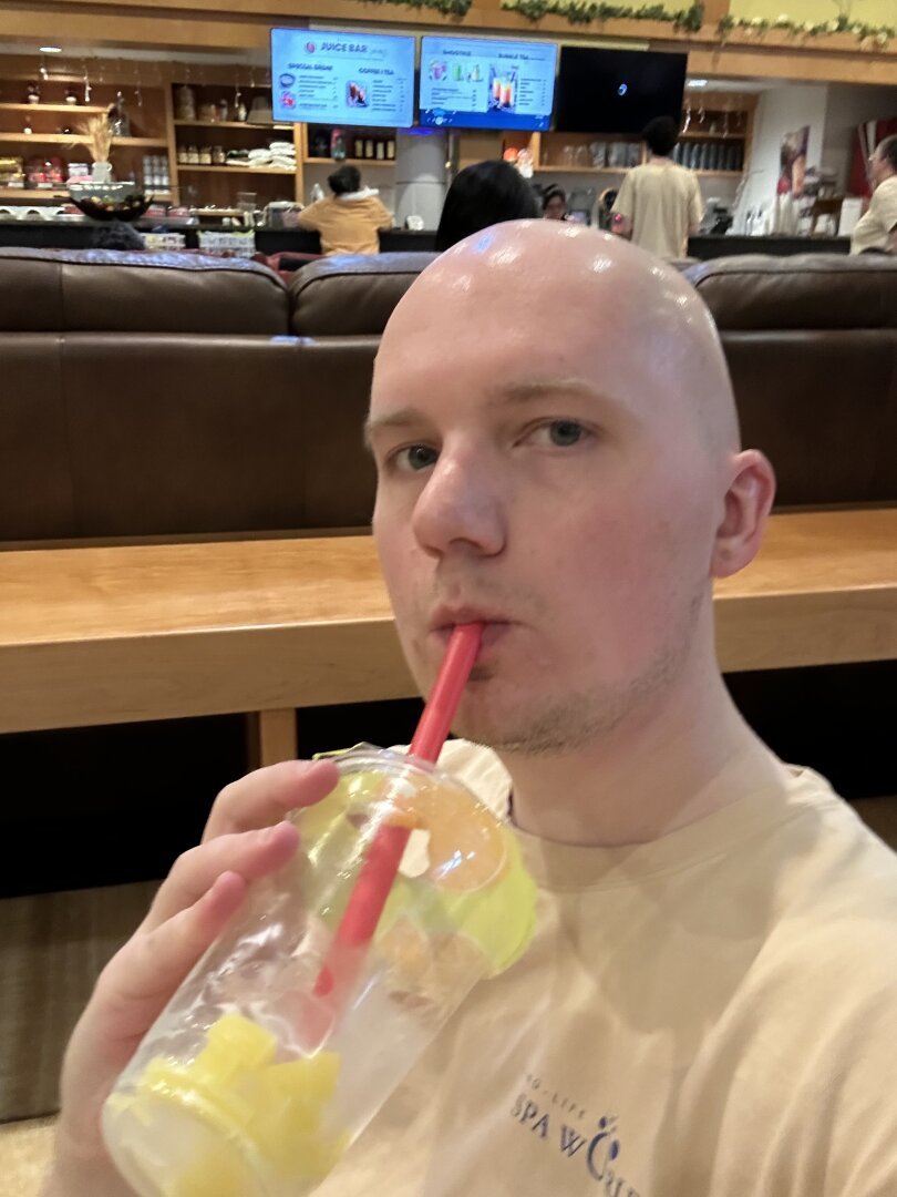 A selfie of me in a beige spa uniform drinking bubble tea