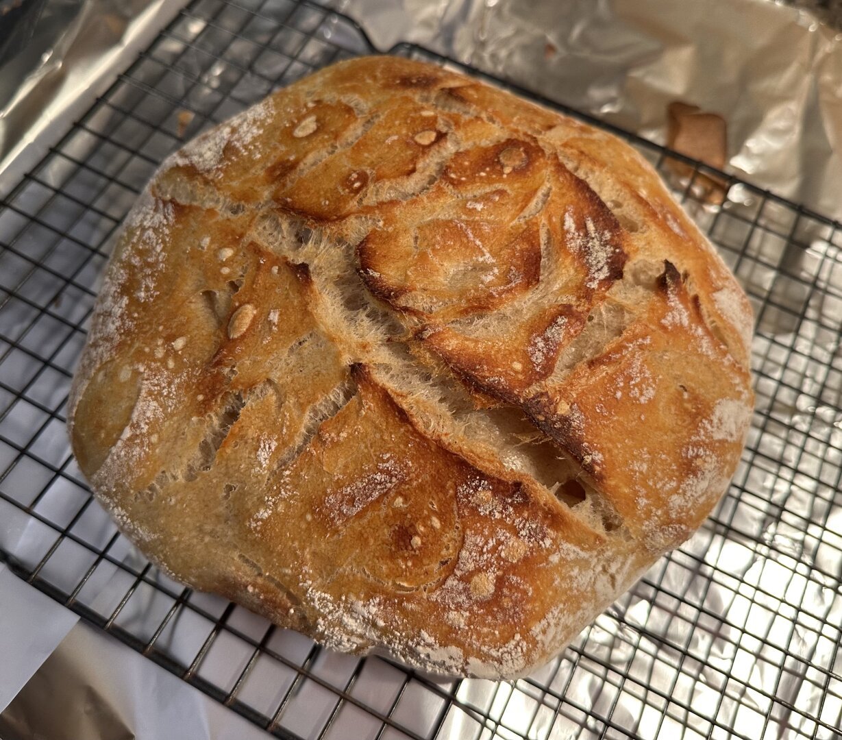 A loaf of sourdough cooling on a wire rack.