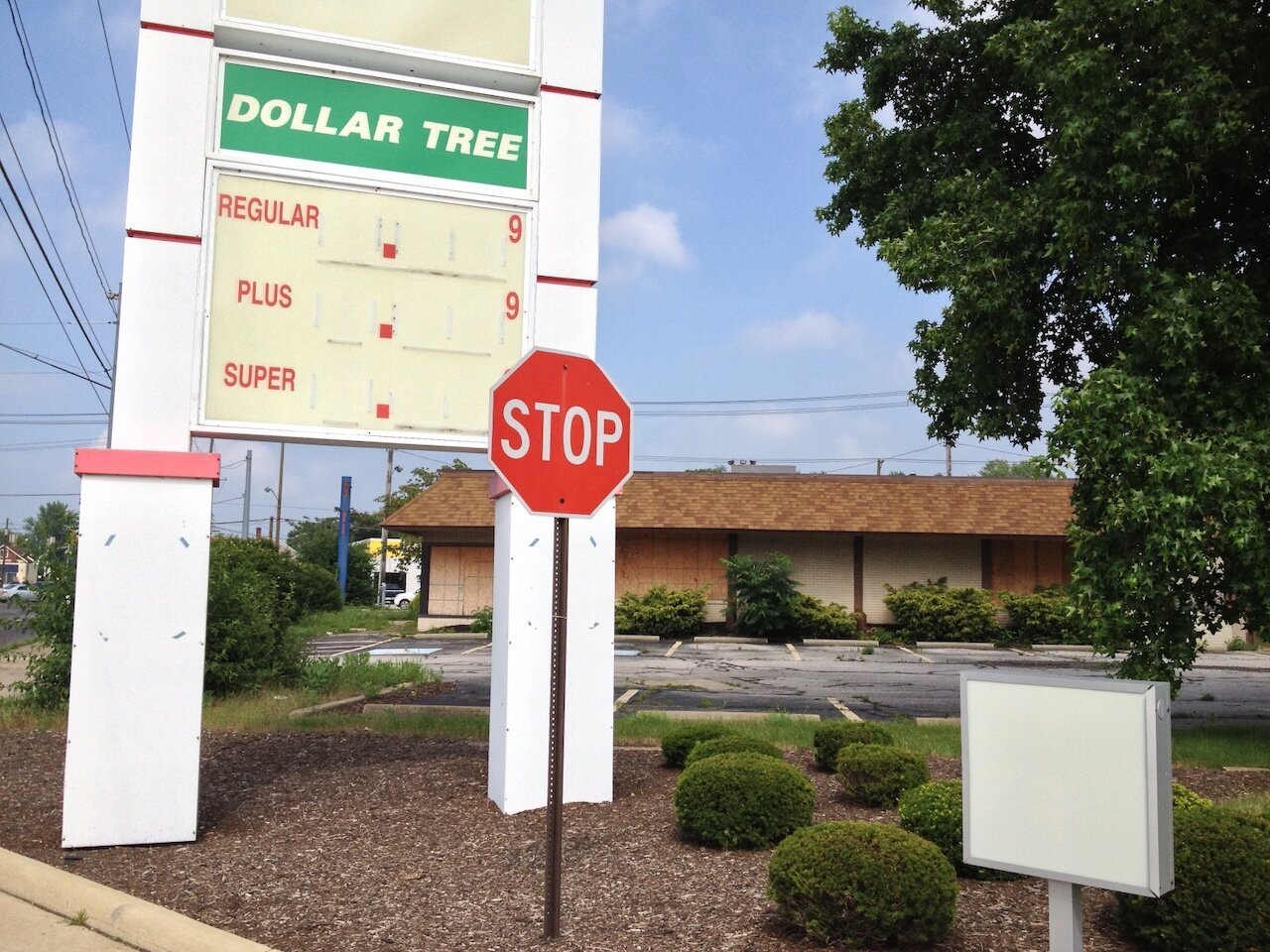 Title: Dollar Store Is A Market Failure

Alt Text: Photograph of a Dollar Tree sign used to advertise gas prices, except that the store is closed and the prices removed. A stop sign is in the foreground beside a blank sign.

Photographer: Marshall Mayer aka @AuthenticPhoto

Date and Time: July 9, 2013 at 4:10 pm

Location: between 1124 and 1138 U.S. 20, Ashtabula, OH USA

License: CC BY-NC-ND 4.0

Caption: Most dollar stores do make money, off of the failure of the capitalist economy to actually pay people. Dollar Tree also owns Family Dollar. They both focus on an extremely cash-strapped demographic, with a household income less than $35,000, and reliant on government assistance. It's one of the fastest-growing market segments, especially in rural America.

Hashtags: #MainStreet #Bankruptcy #Recession #Poverty #FoodDesert #DollarStore #Authentic #Photography

Source: https://take-note.com/note-takers/marshall--mayer/notes/dollar-store-is-a-market-failure/view