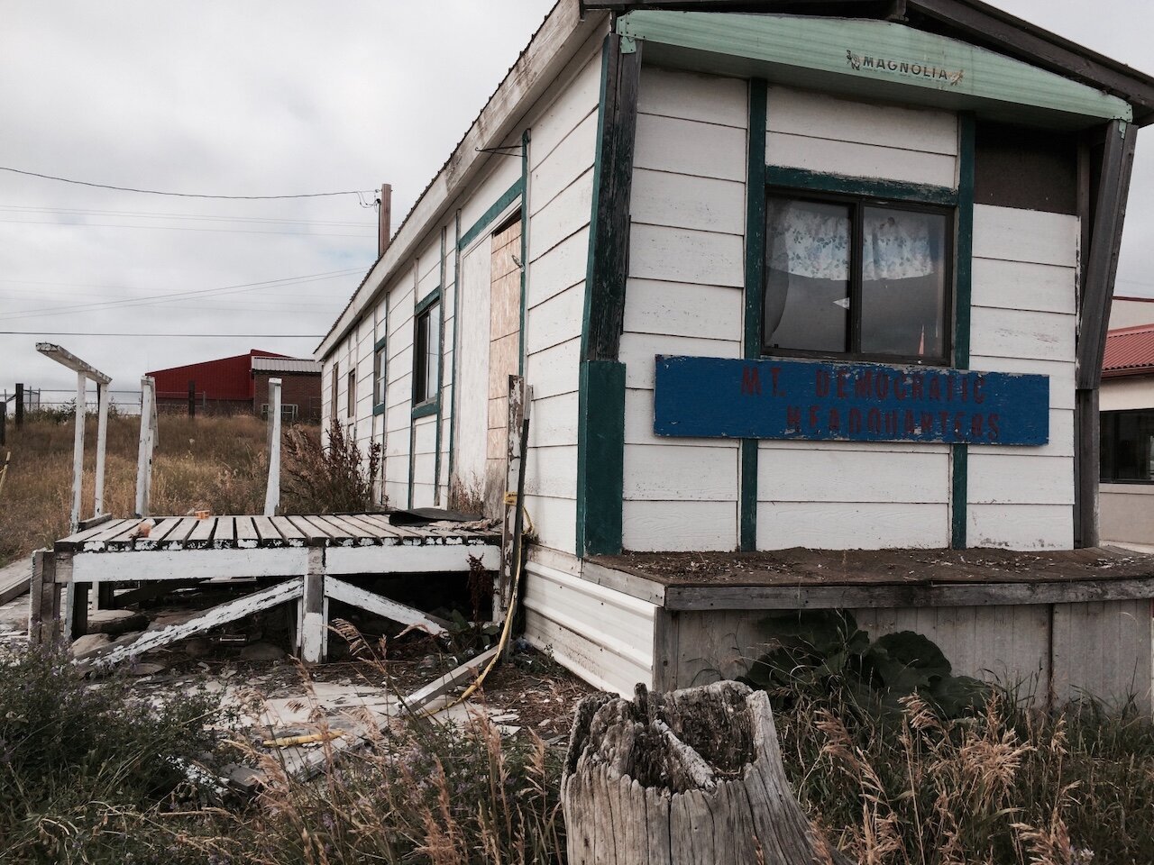 Title: Once Dominant Political Party in Dramatic Decay

Alt Text: Photograph of an abandoned mobile home.It's hard to read but the sign on the front of the building reads, 