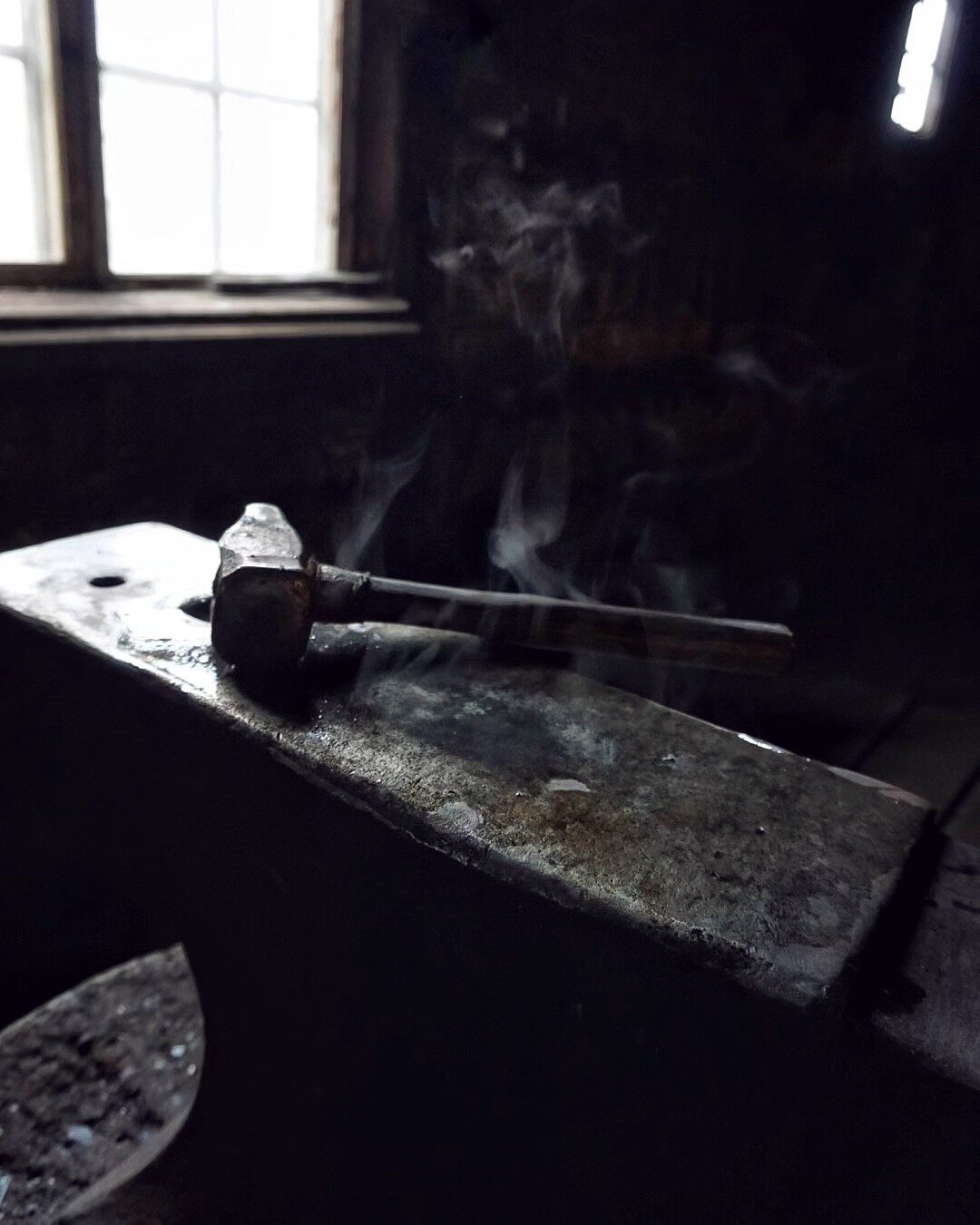 Photo of a steaming hot anvil. Hammer resting on top