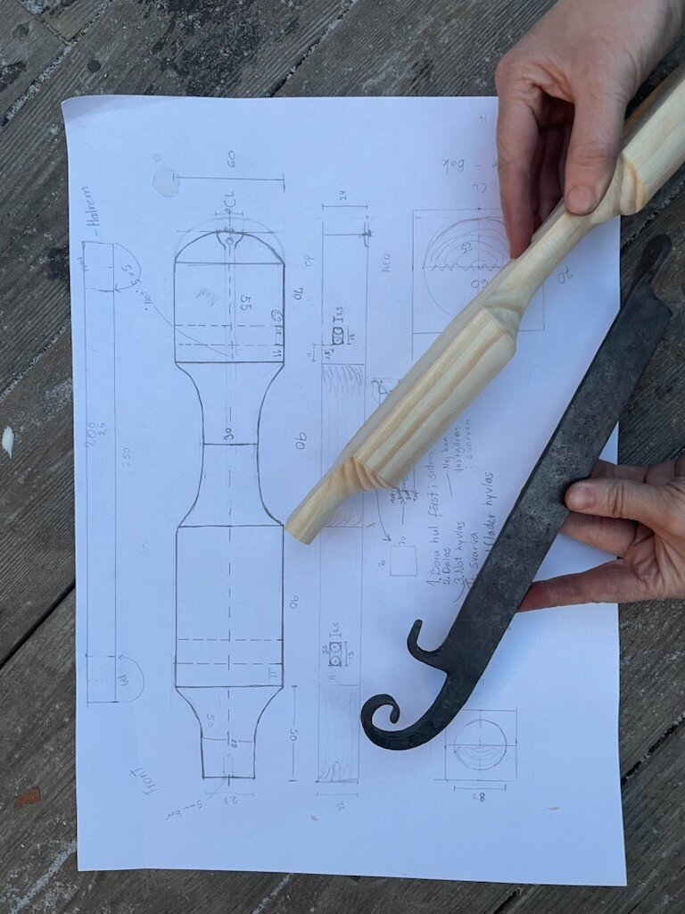Photo of a blueprint of old ice skates, and hands holding a reconstructed skate in parts