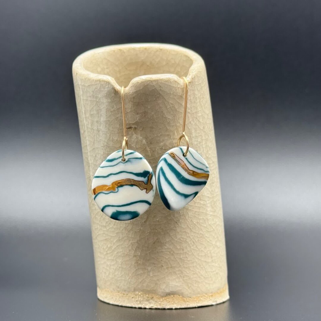 Boucles d’oreilles ronde en porcelaine fabriquées avec une technique de type  Nerikomi ; mélange de terre colorées teintées dans la masse. Le fond de la pièce en porcelaine est blanc et de délicates rayures colorées apparaissent sur toute la surface. Les boucles d'oreilles sont rehaussées d'or appliquée en 3ème cuisson.