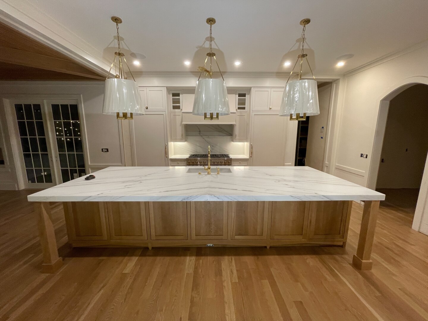 White oak kitchen island with inset fronts and a marble top.