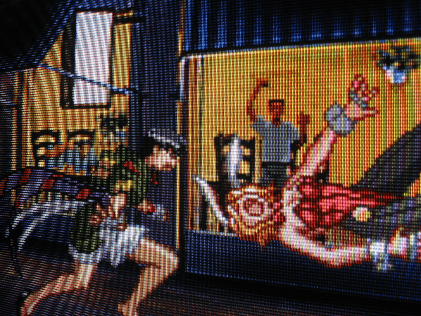 Elegant Assassin Kyoko Kirishima tosses American Playboy Bunny Erina Goldsmith over her shoulder like a sack of flour in the middle of the street, bouncing her off the pavement like a slightly-deflated basketball. Illuminated inside a storefront a man presses up against the window, captivated, zombie-like, by the lady melee.