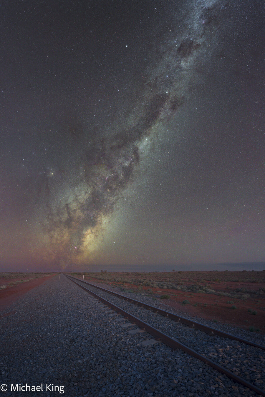 The Milky Way rising in the distance with a railway line leading from the foreground.