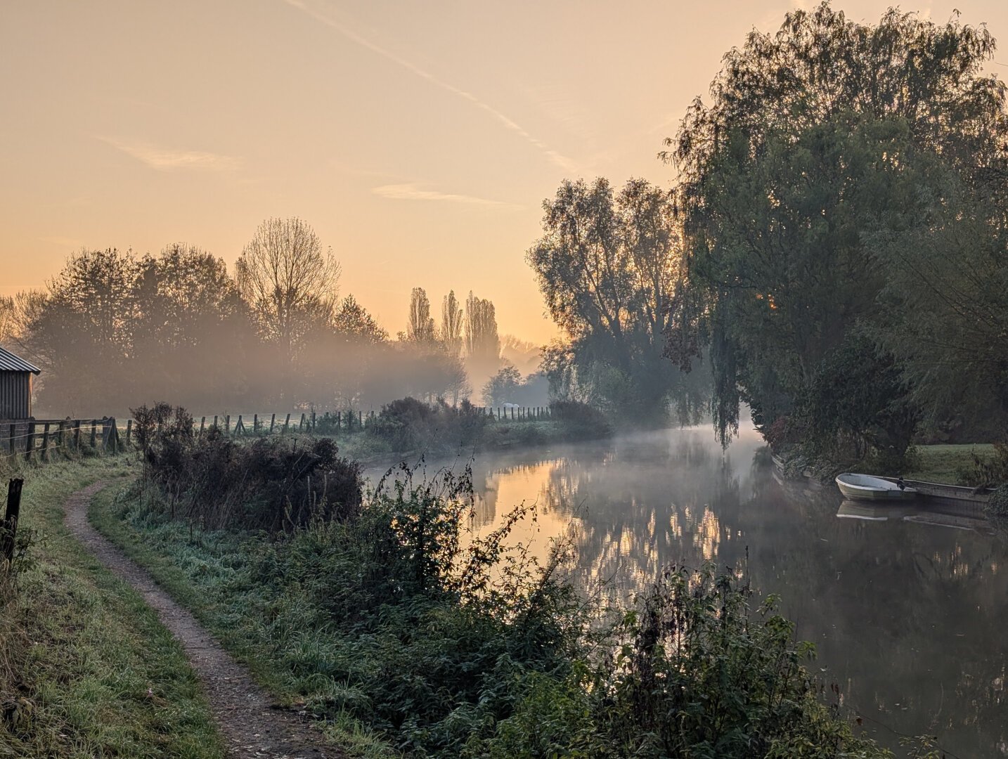 Small river during sunrise. Red sky, with some fog.