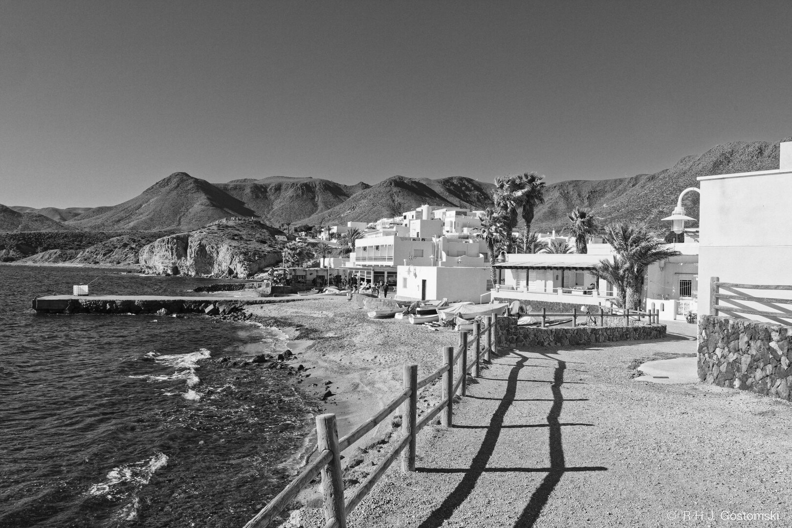 A view of La Isleta del Moro on the coast by the sea. A footpath leads down to the beach, with La Isleta del Moro behind