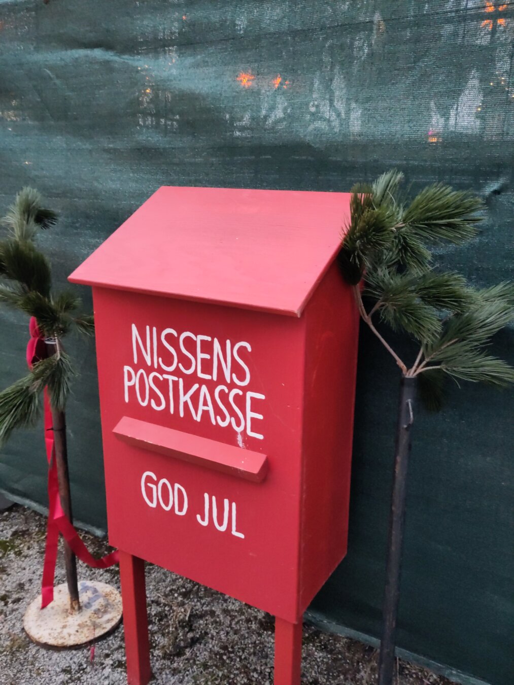 A red postbox that says Nissens Postkasse - God jul. Translation is Santa postbox - Merry Christmas.