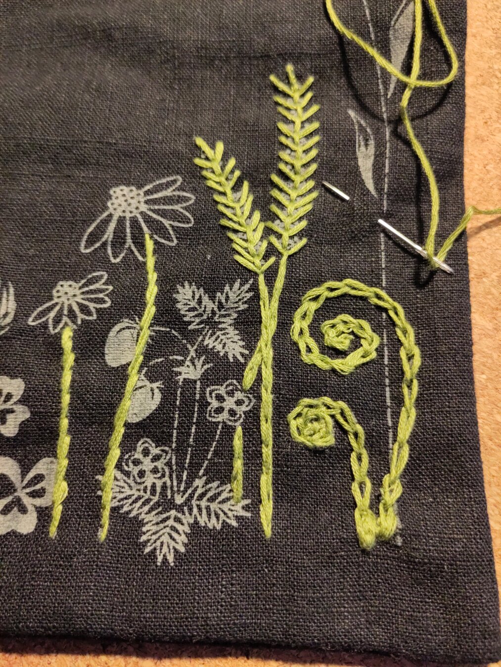 Black embroidery project bag with green embroidery stems in split stitch, stem stich, fly stich and chain stitch