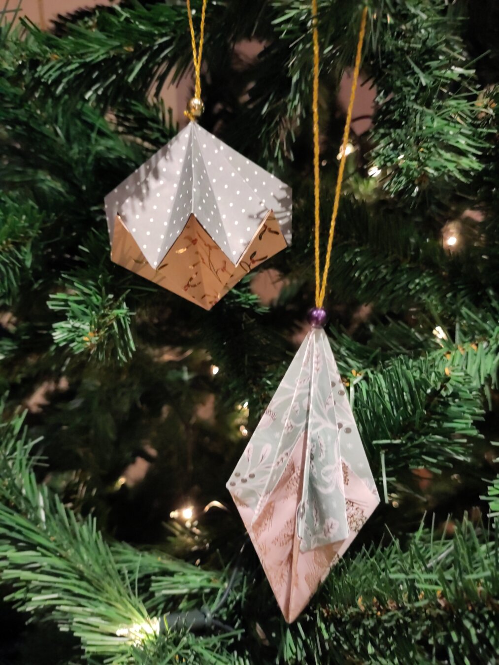 Two different modular origami ornaments in a Christmas tree with light blue patterned paper and white patterned paper.