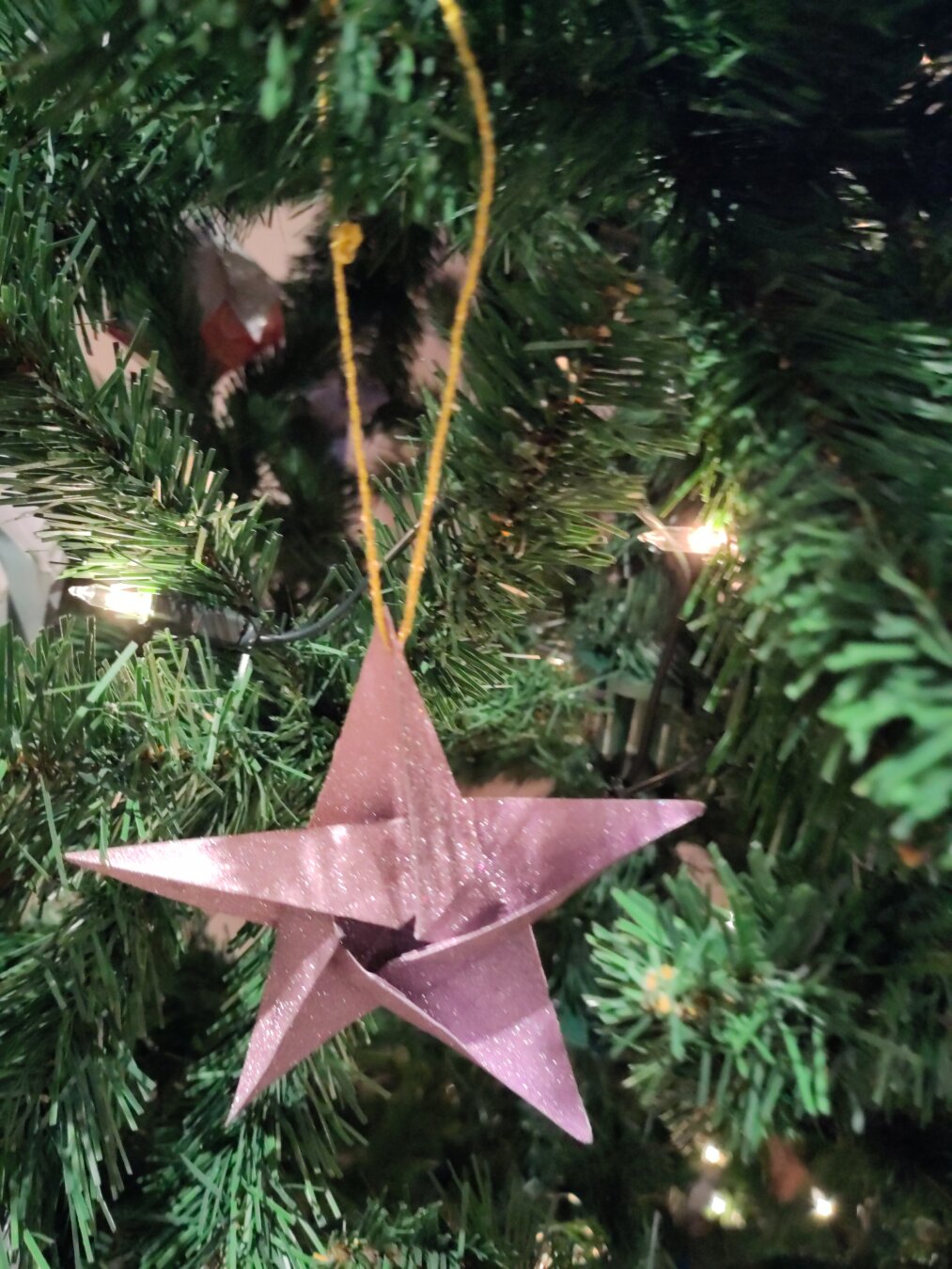 Origami star of light purple glitter paper in a Christmas tree