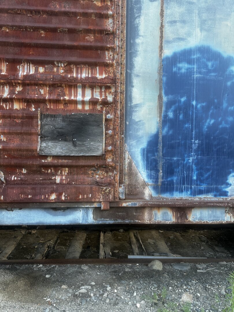 Close(ish)-up photo of a rusted, blue train car.