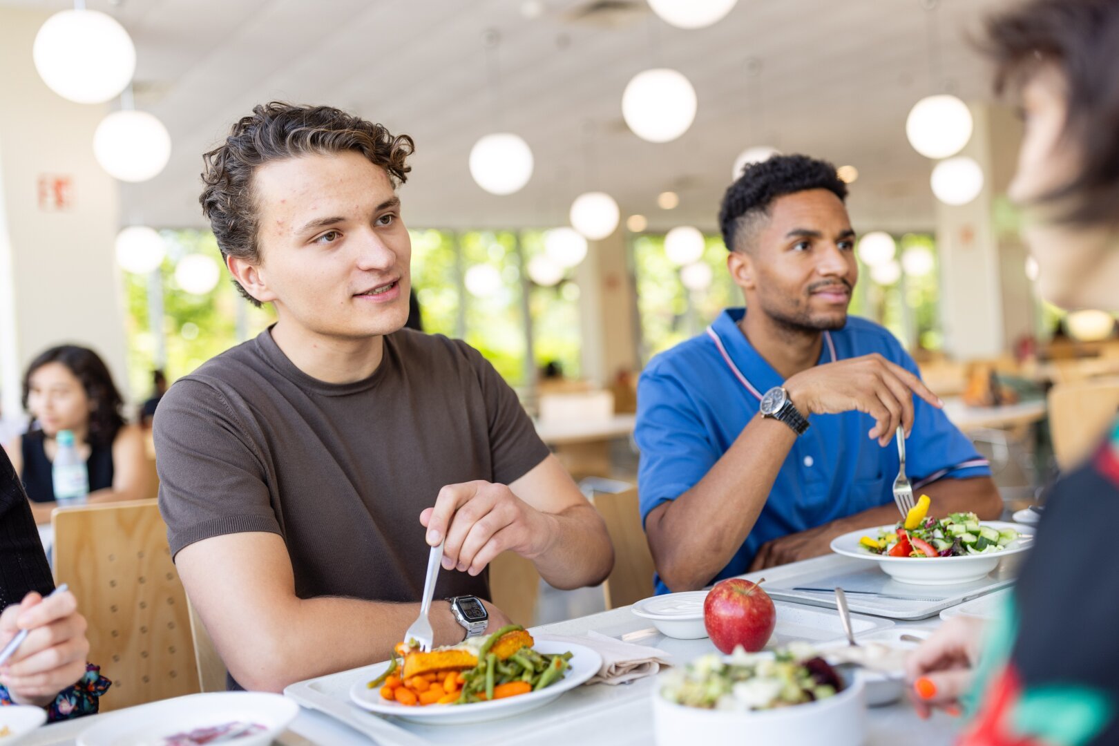 Symbolbild: Ein Student sitzt in der Mensa beim Essen.