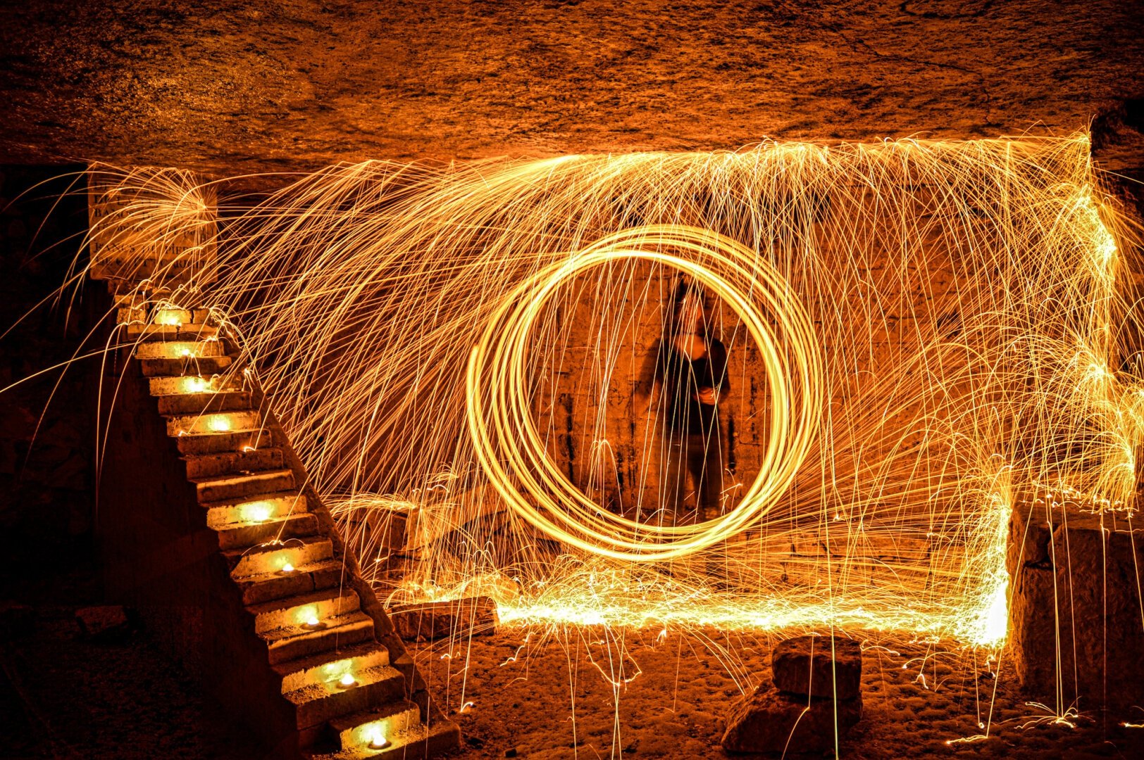 Underground room in the catacombs, illuminated by the sparkles of an incandescent steelwhool; long exposure photography.