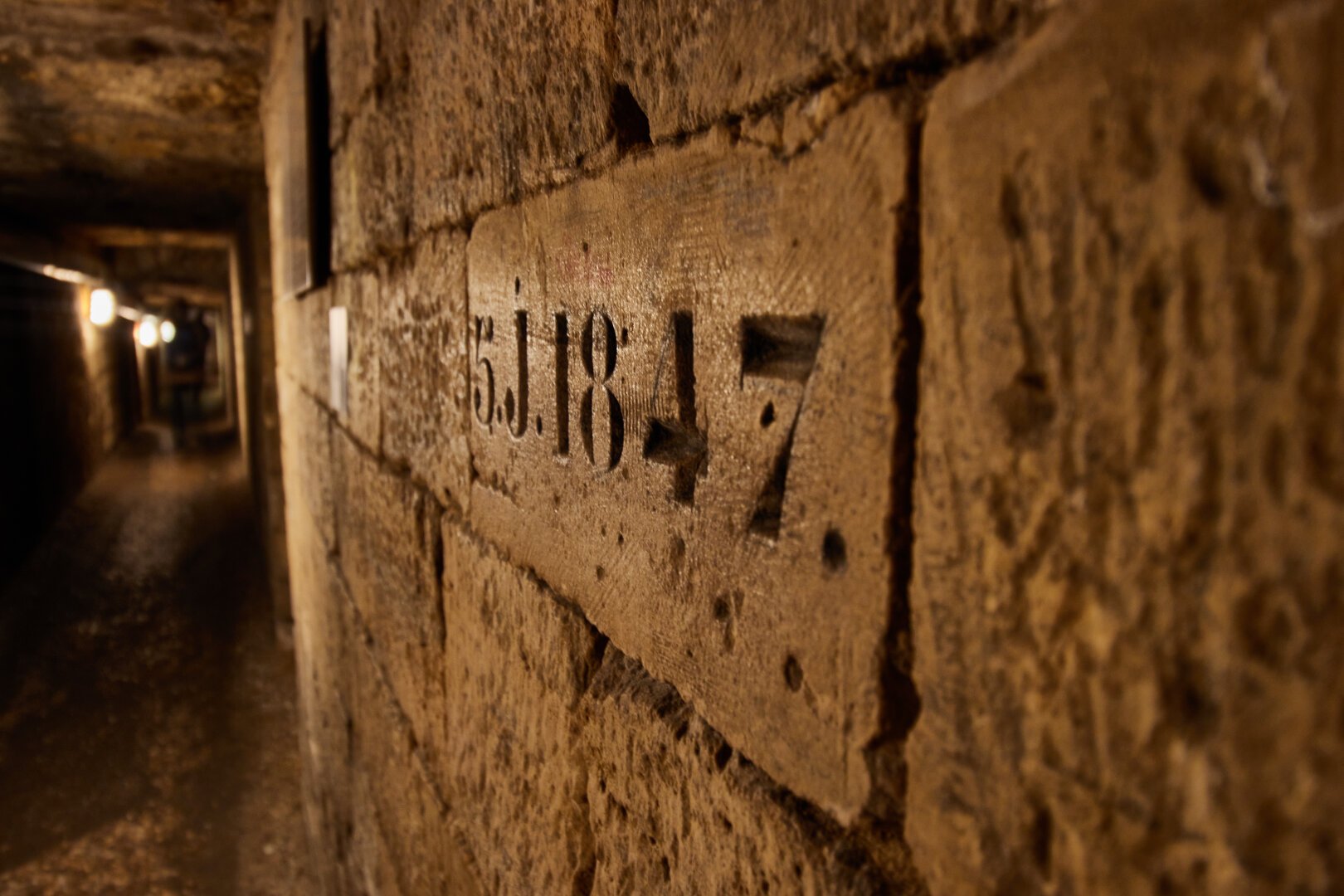 Corridor in the catacombs, close up on the bricks in which were carved the renovation year (1847)