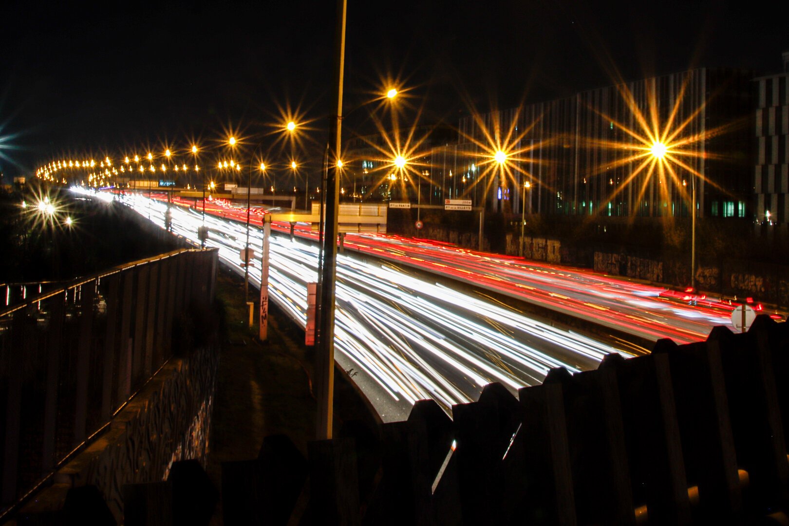 A long exposure of a road at night, lighten up by street lights and car headlights trails. View from above the road.