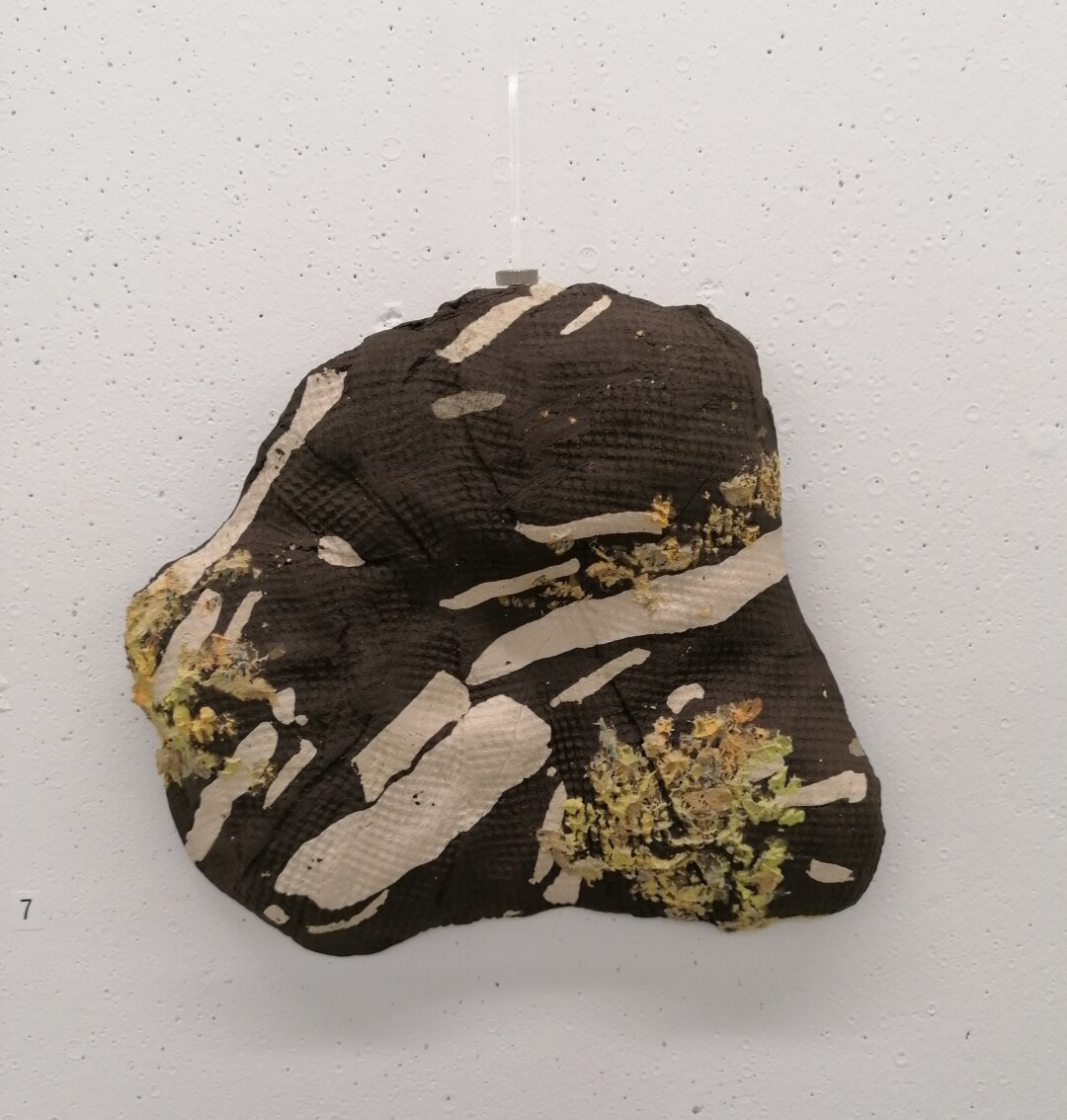 Stentøjsler moduleret til at ligne lavbegroet rombeporfyr med en stof pregning I overfladen.

Stonewear clay shaped to look like the stone type rombeporfyr.