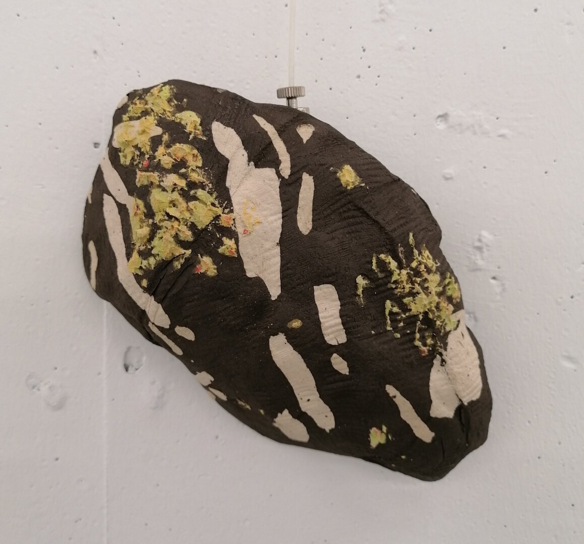 Stentøjsler moduleret til at ligne lavbegroet rombeporfyr med en stof pregning I overfladen.

Stonewear clay shaped to look like the stone type rombeporfyr.