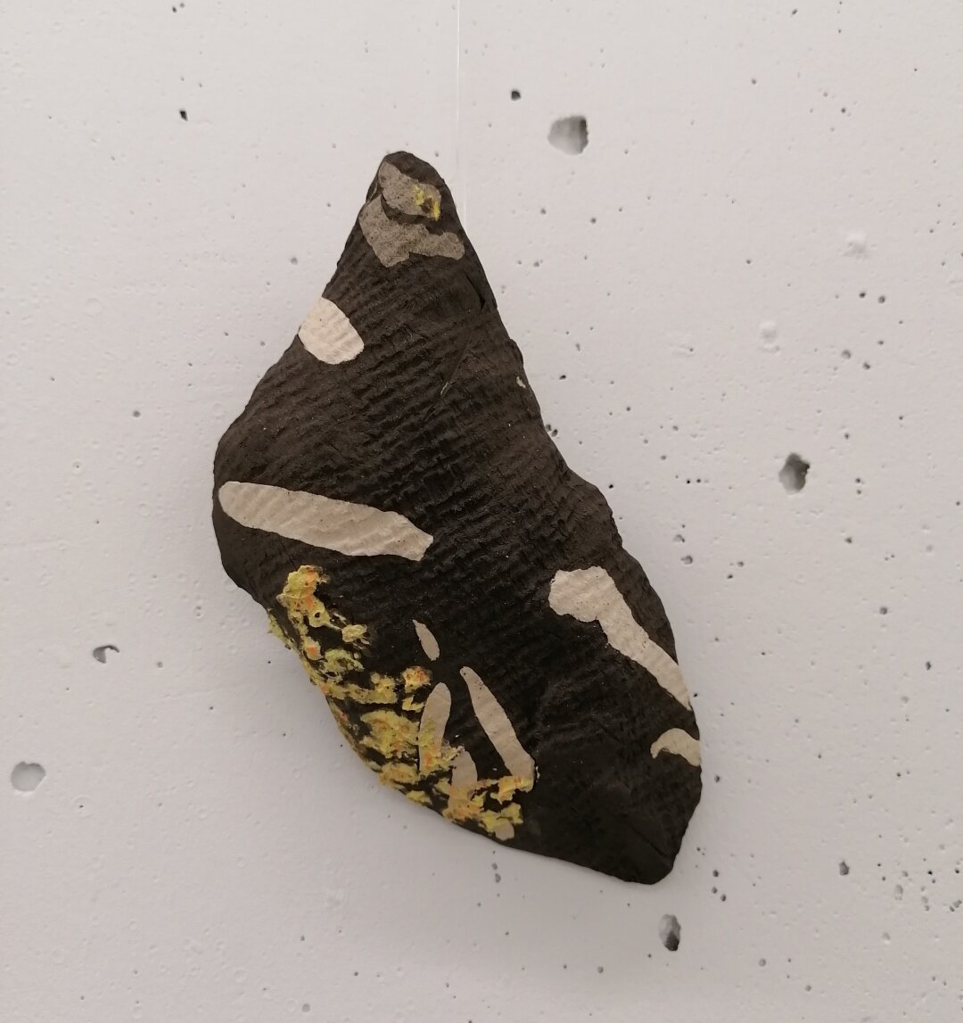 Stentøjsler moduleret til at ligne lavbegroet rombeporfyr med en stof pregning I overfladen.

Stonewear clay shaped to look like the stone type rombeporfyr.