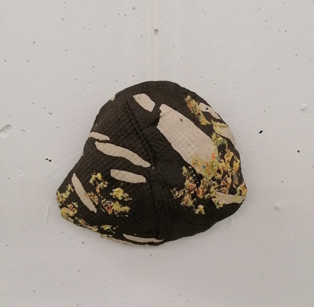 Stentøjsler moduleret til at ligne lavbegroet rombeporfyr med en stof pregning I overfladen.

Stonewear clay shaped to look like the stone type rombeporfyr.