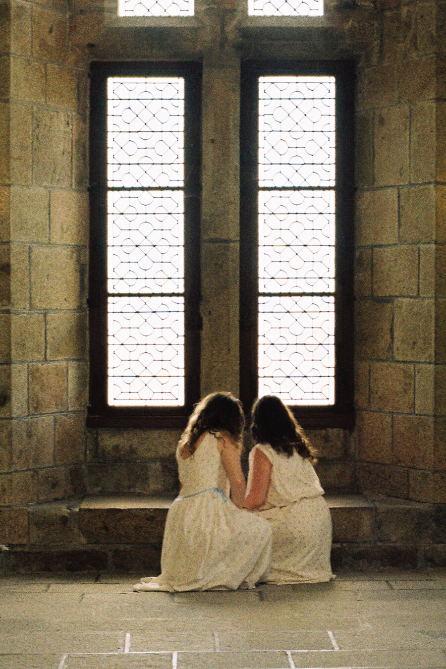 Two girls in front of a monastery window