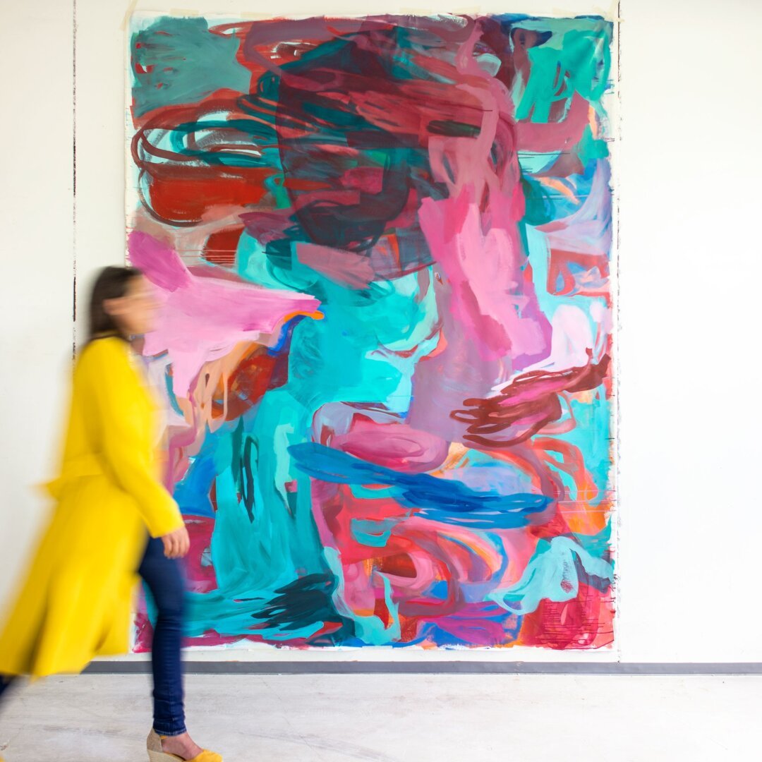 Artist in motion, passing by a large abstract canvas
