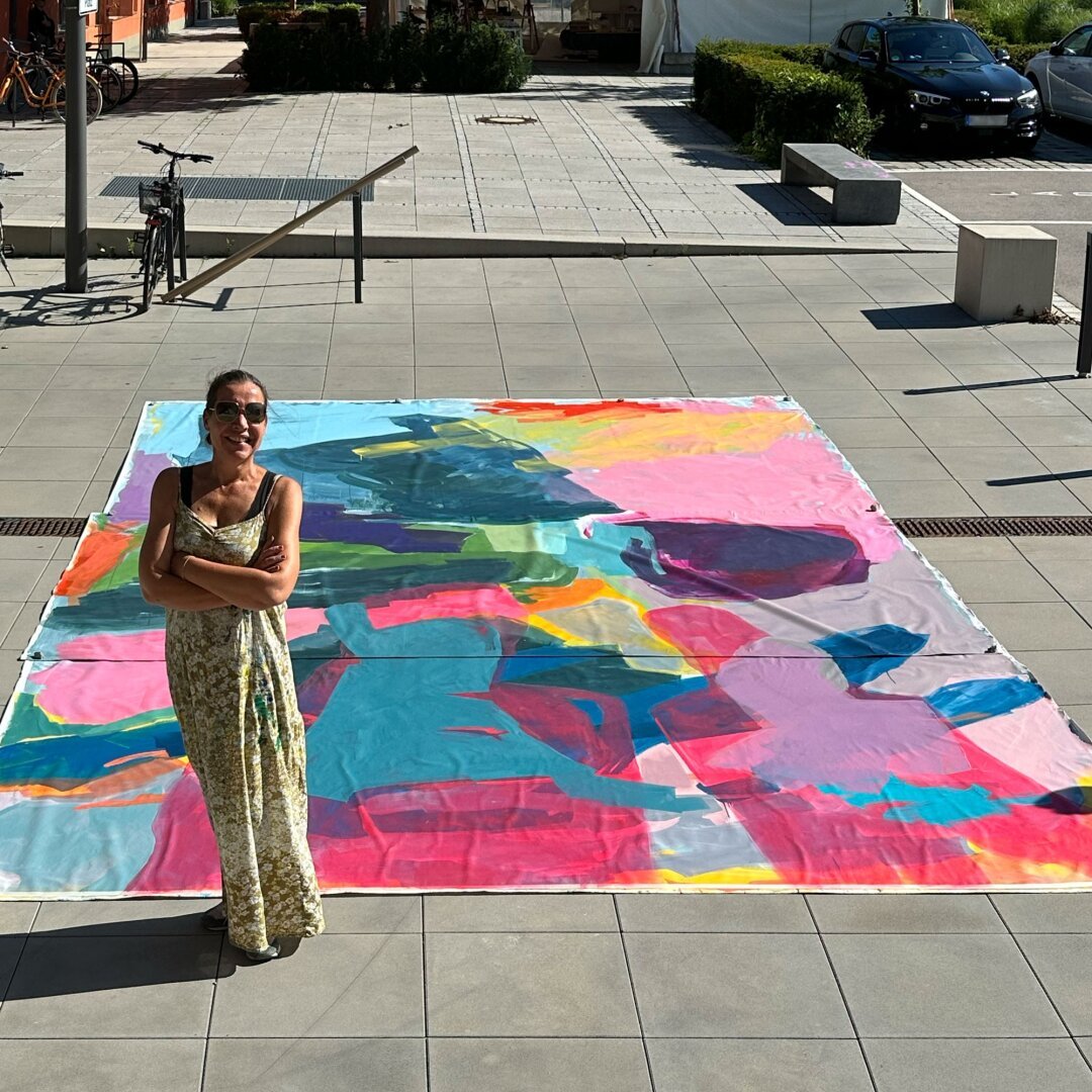 Artist standing outside in front of a huge canvas (4 by 6 metres), sunny light, perspective from above