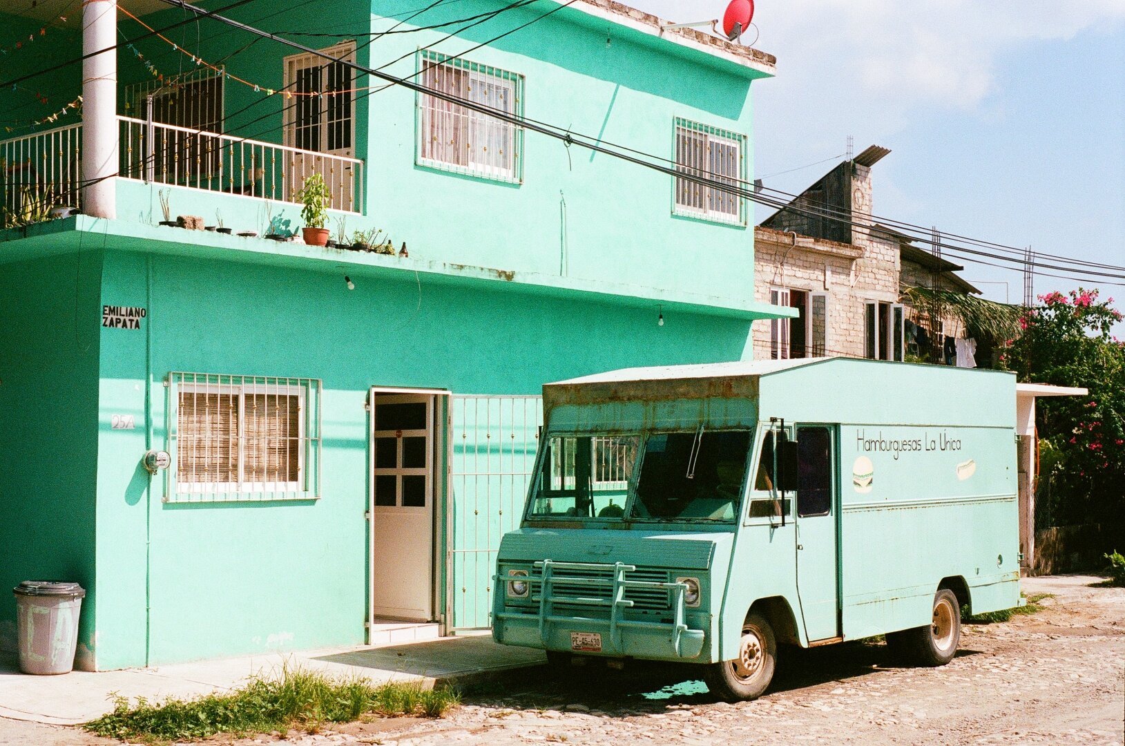 Green food truck in front of a matching green house