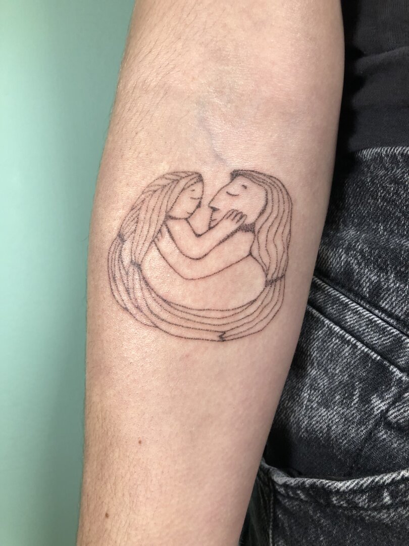 un tatouage de câlin au handpoke sur le bras