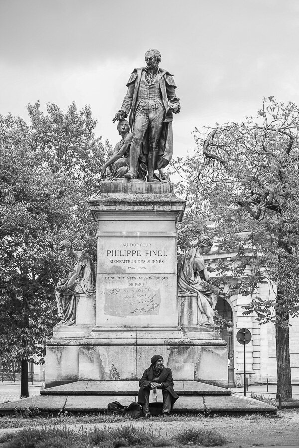 Dans le rétroviseur, Paris 2016, Un homme assis au pied de la statue de Philippe Pinel devant l'hôpital de la Salpêtrière, Scène de vie urbaine.

Photographie Vincent Dufrène