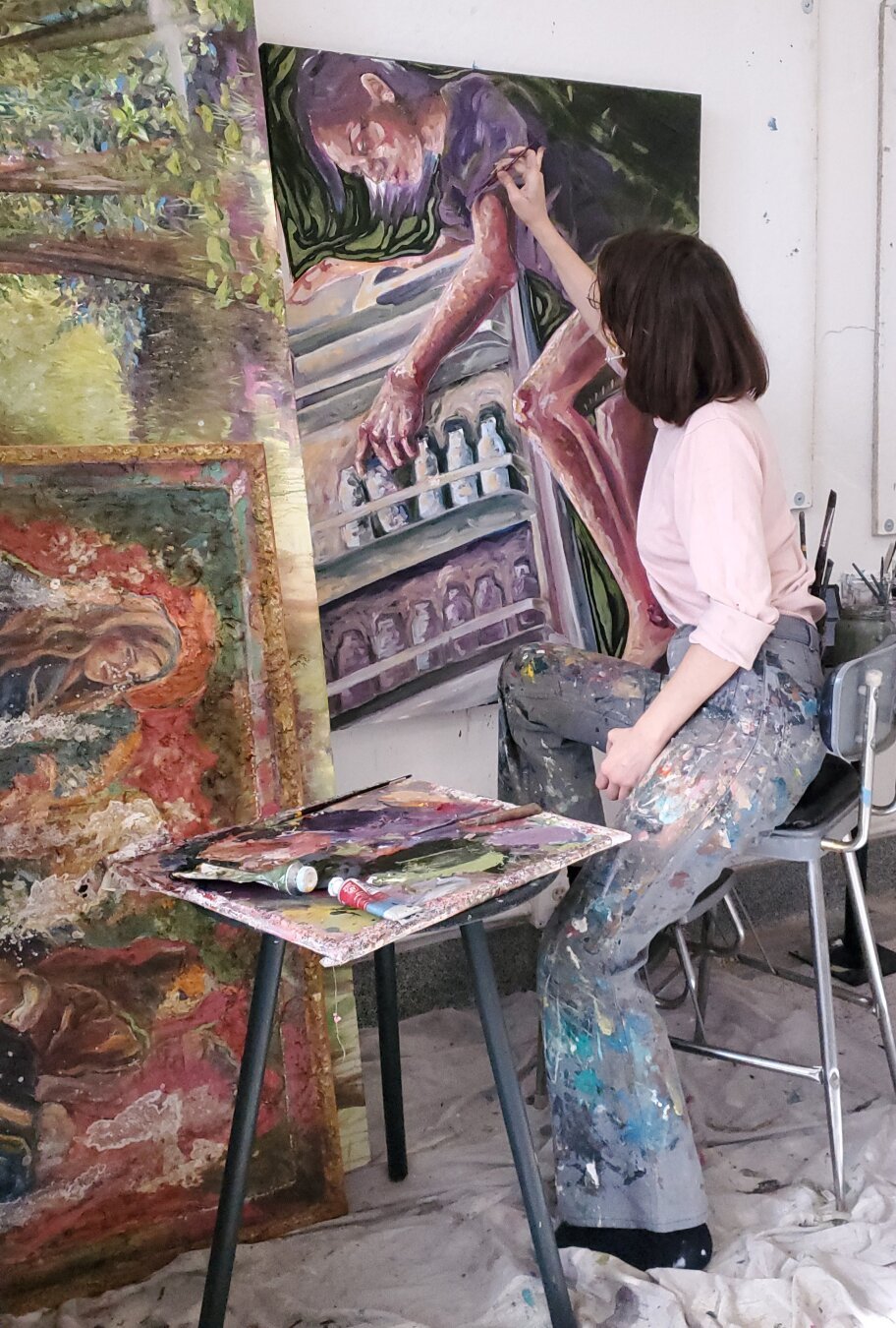 A woman working on a painting in her studio.