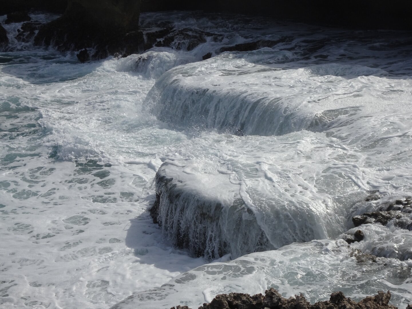 Water receding down to the sea over naturally created steps.
