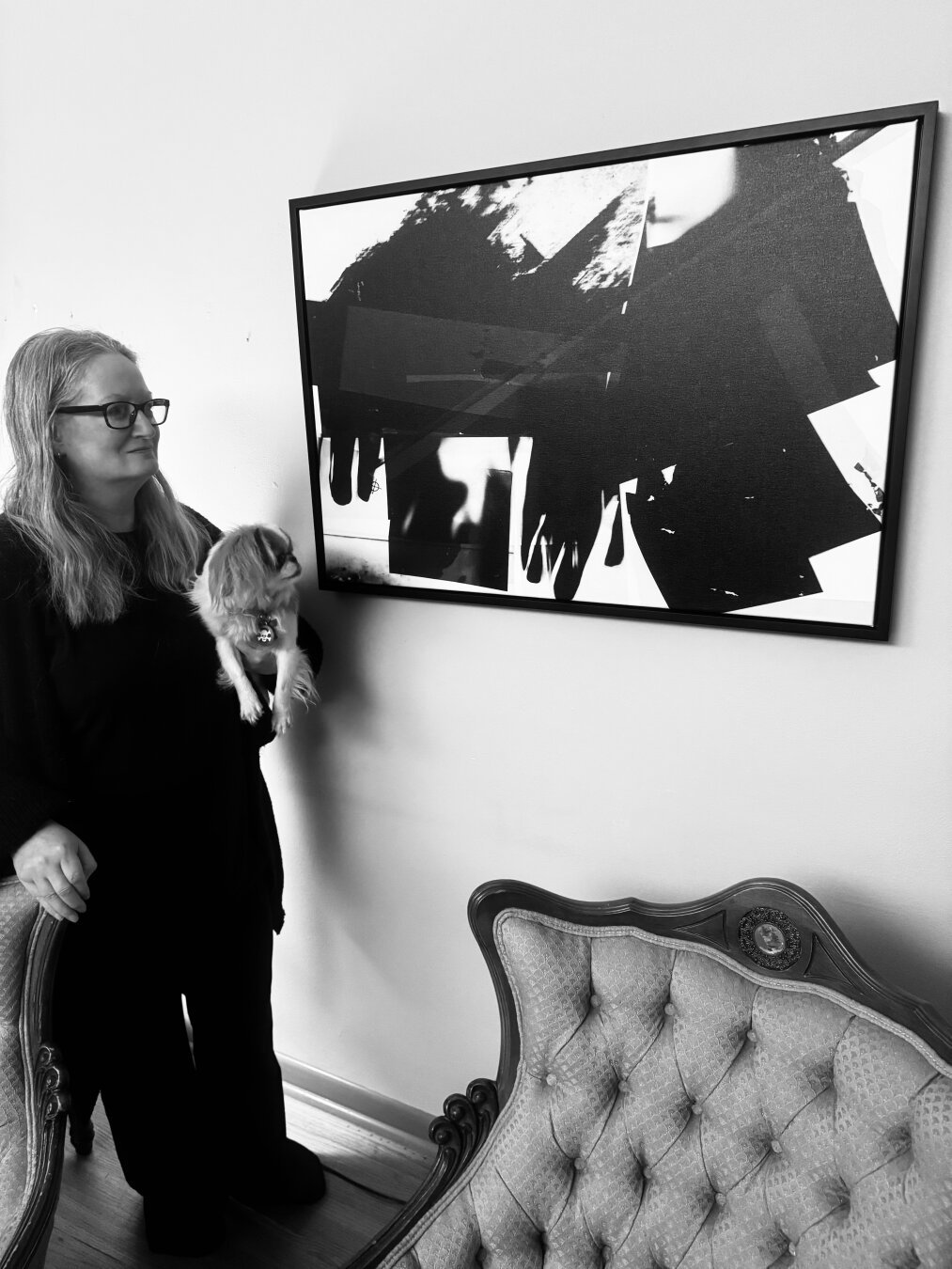 Amy and small dog displaying abstract, geometric artwork in black and white